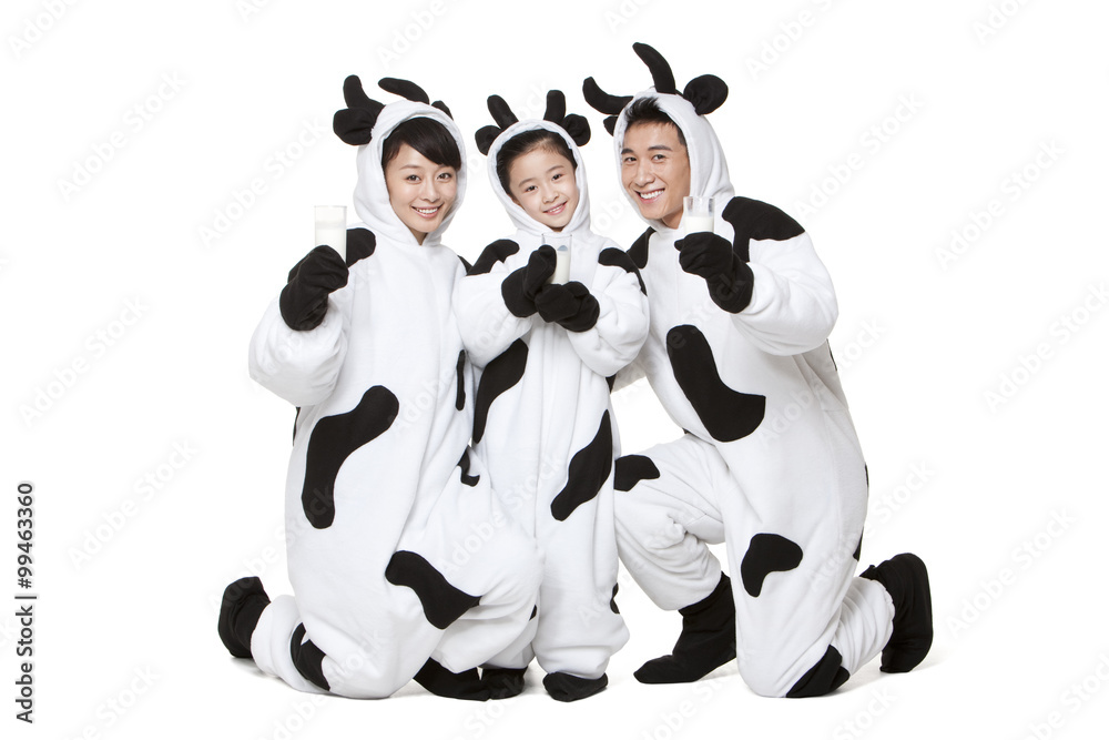 Family in cow costumes with glasses of milk playing around