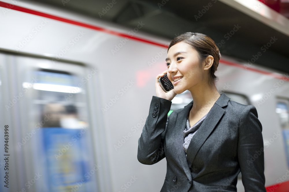 Businesswoman using cellphone in the subway station