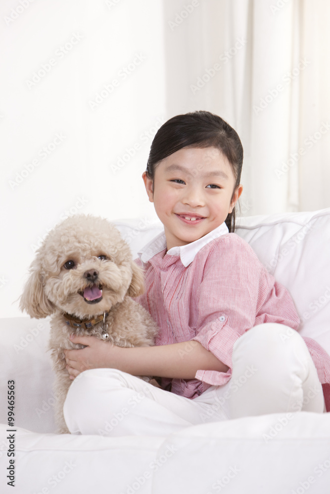 Little girl playing with a pet toy poodle