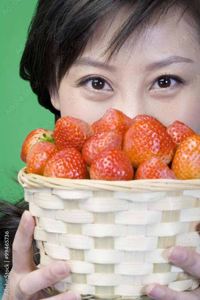 Woman on green background with strawberries