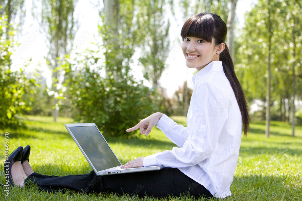 Woman in park with laptop