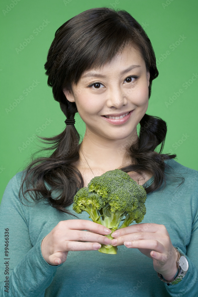 Woman on green background with broccoli