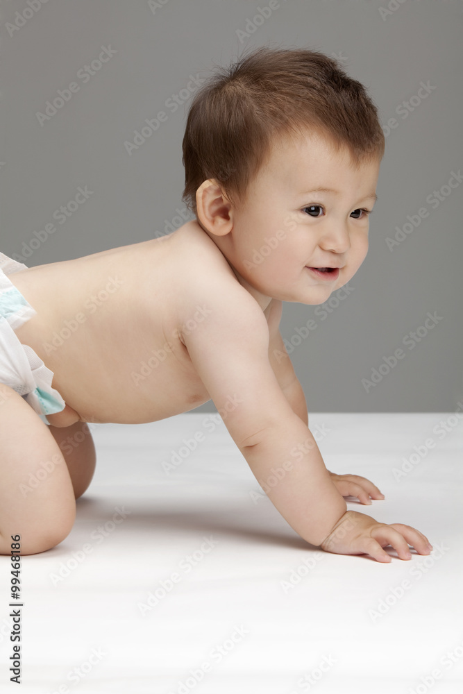 Studio shot of a cute baby boy crawling