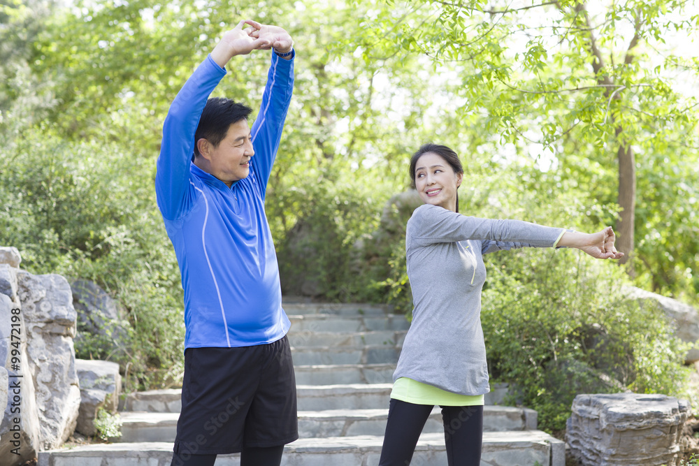 Happy mature couple exercising in park