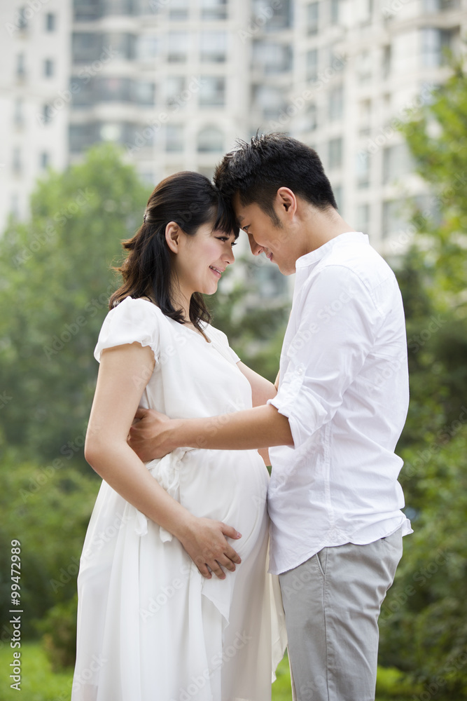 Pregnant woman and her husband embracing