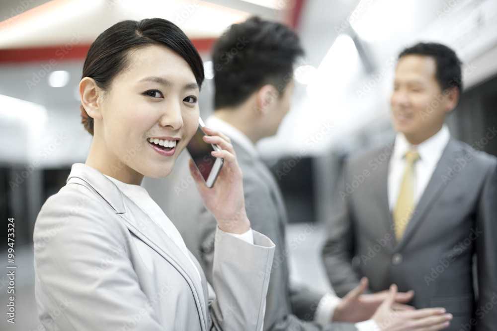 Business persons waiting for train on subway platform