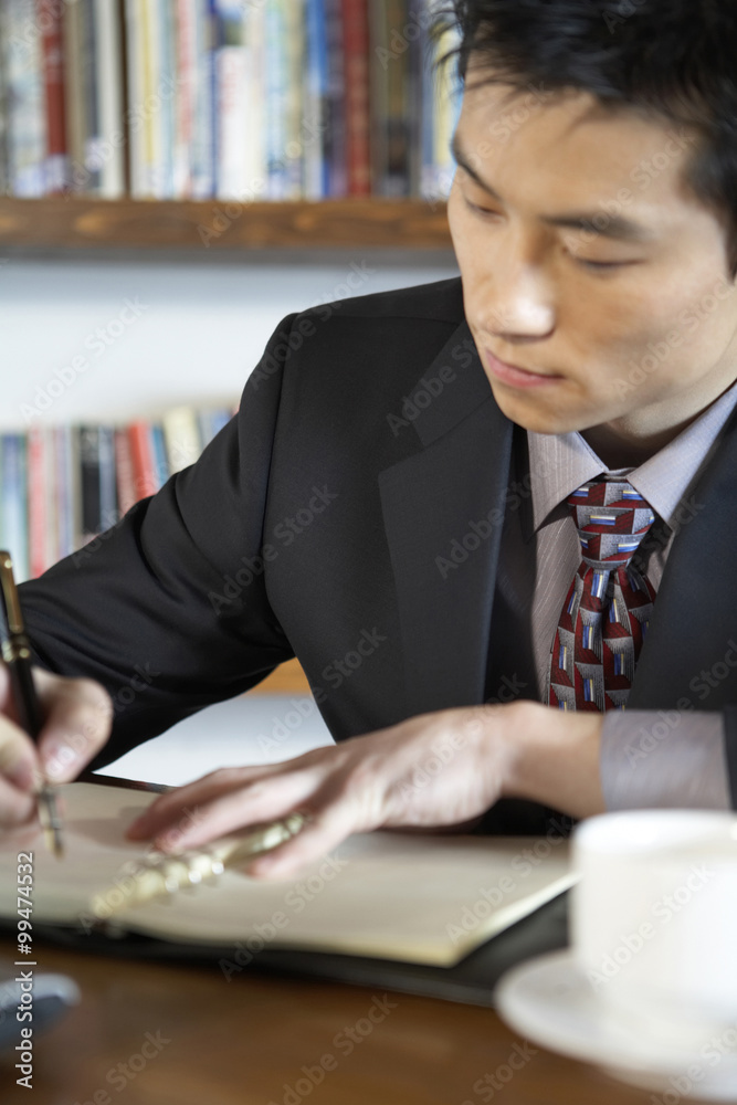 Businessman Writing In A Book