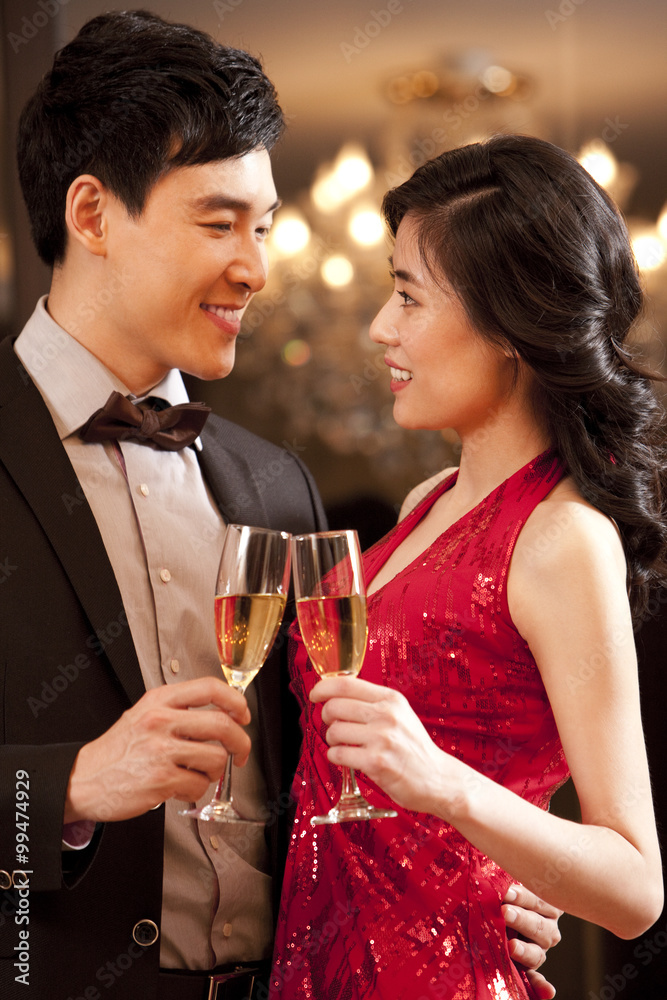 Young couple having champagne in a luxurious room