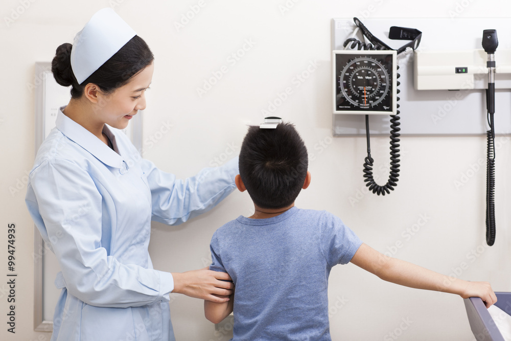 Nurse measuring boy in examination room