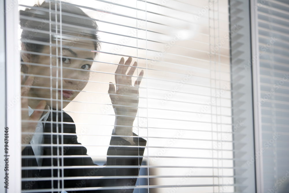 Businesswoman behind blinds