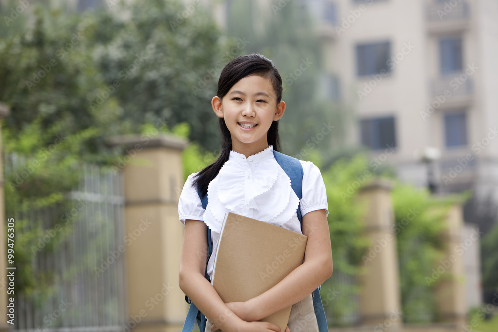 校园里穿着制服、手里拿着书的可爱女学生