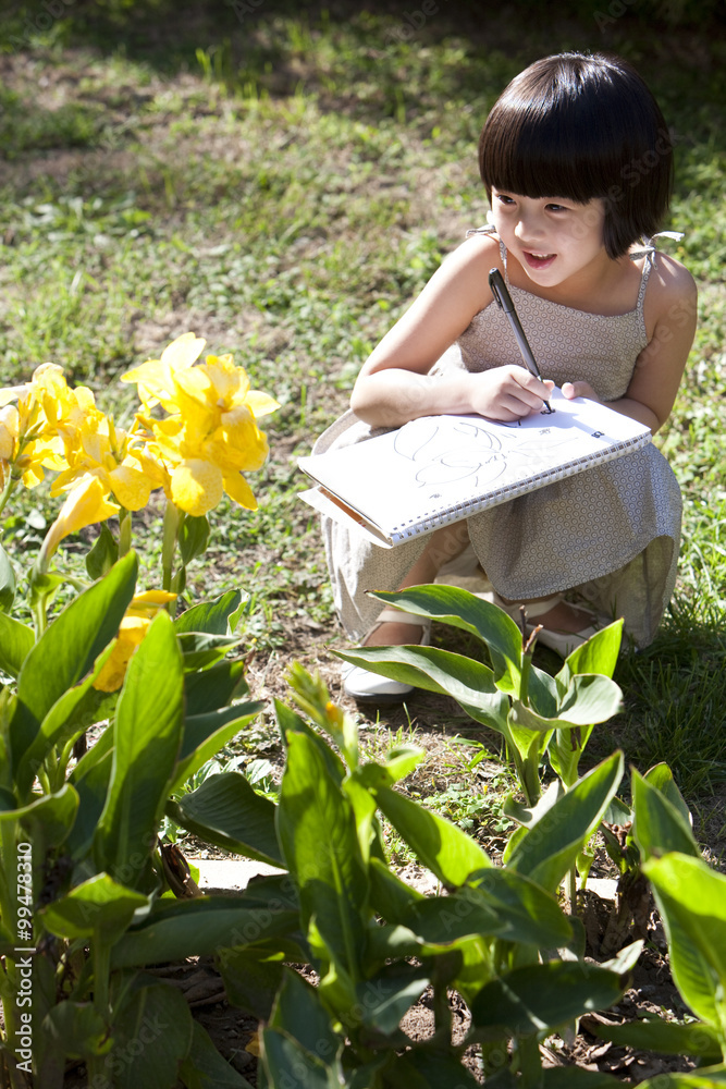 Little girl painting in garden