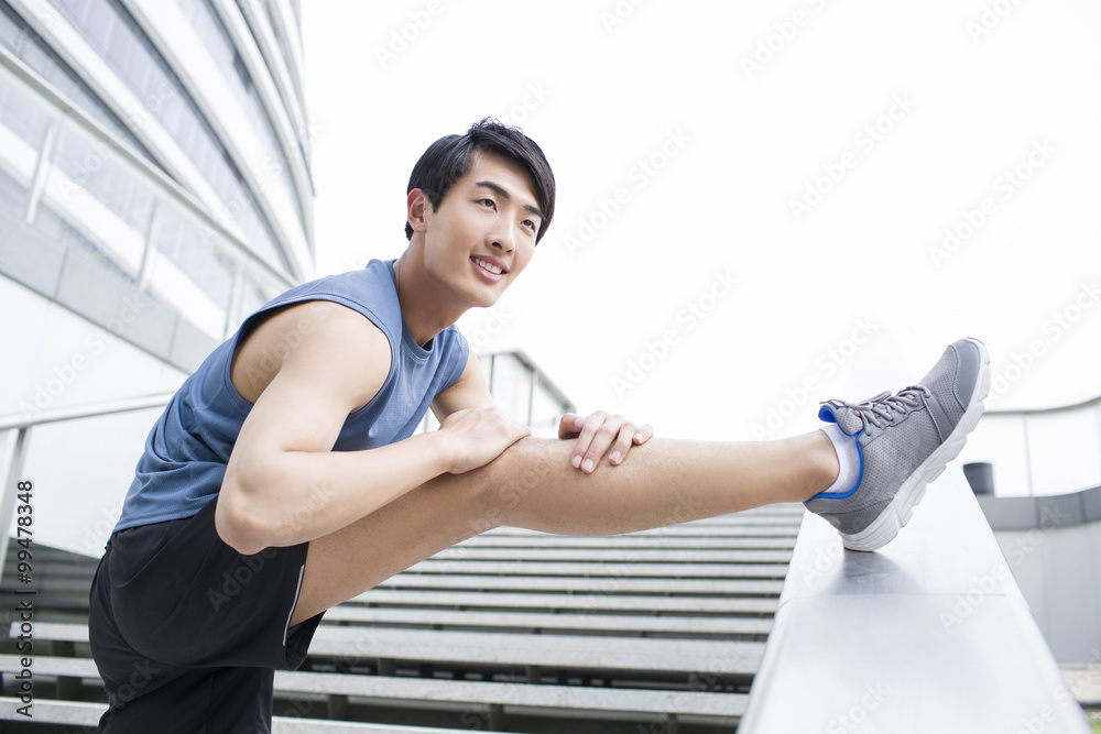 Young man stretching leg