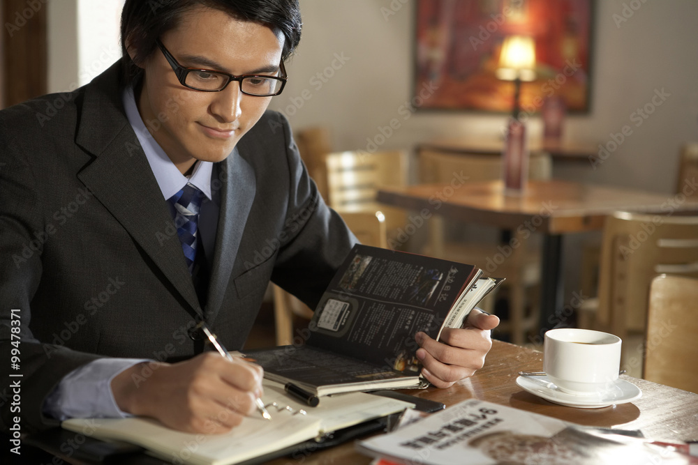 Businessman Writing In A Book