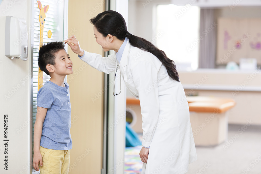 Doctor measuring boys height