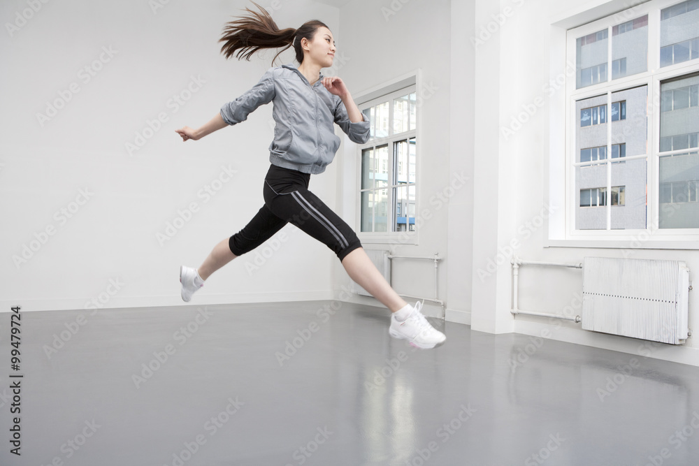 健康的年轻女子在空中跳跃