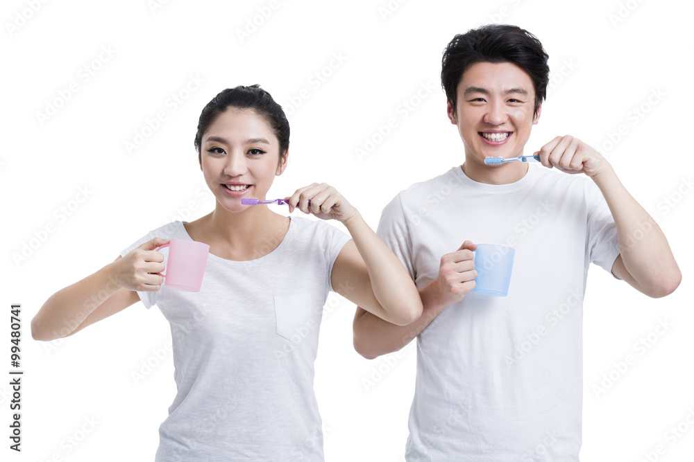 Cheerful young couple brushing teeth