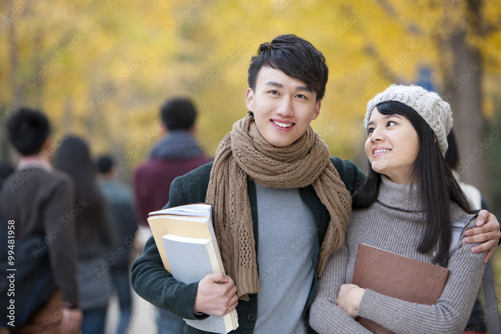 Cheerful young couple on campus in autumn