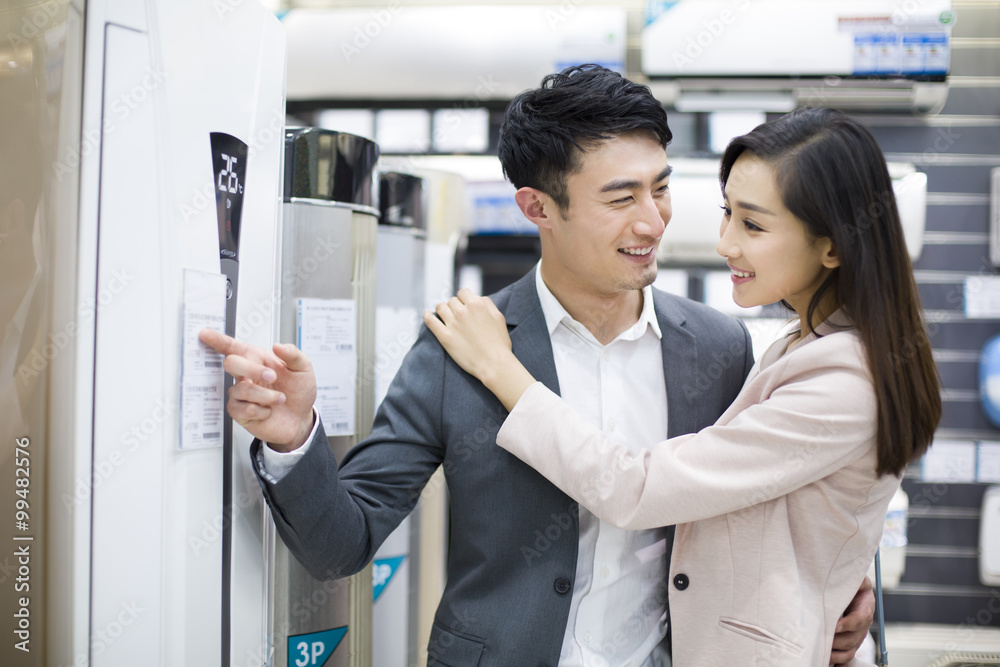 年轻夫妇在电子商店买空调