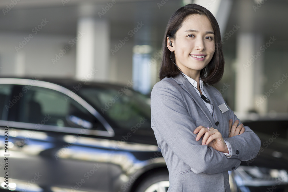 Confident car saleswoman with headset