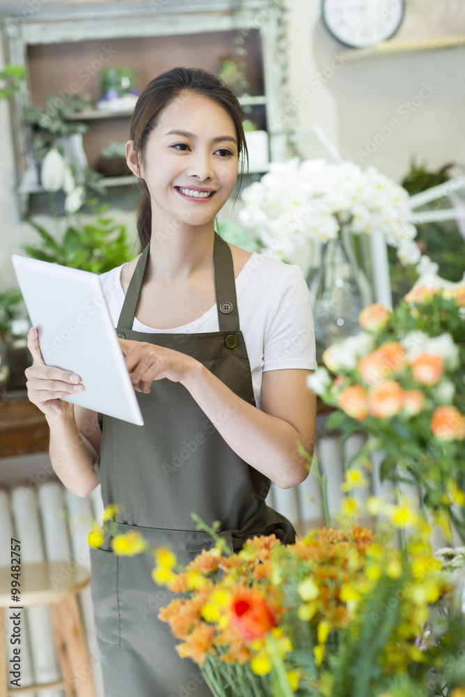 女花店老板在店里使用数字平板电脑