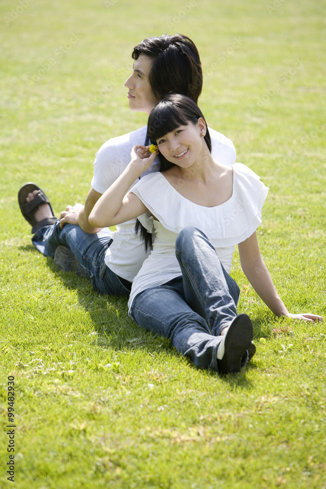 Young couple sitting back to back