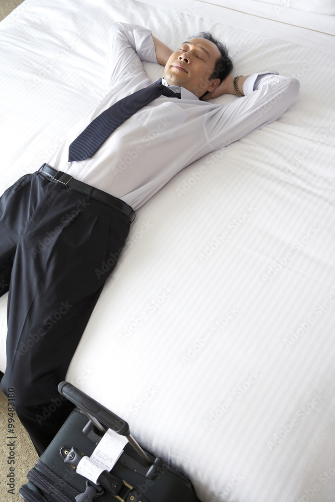 Man in business attire relaxing in bed