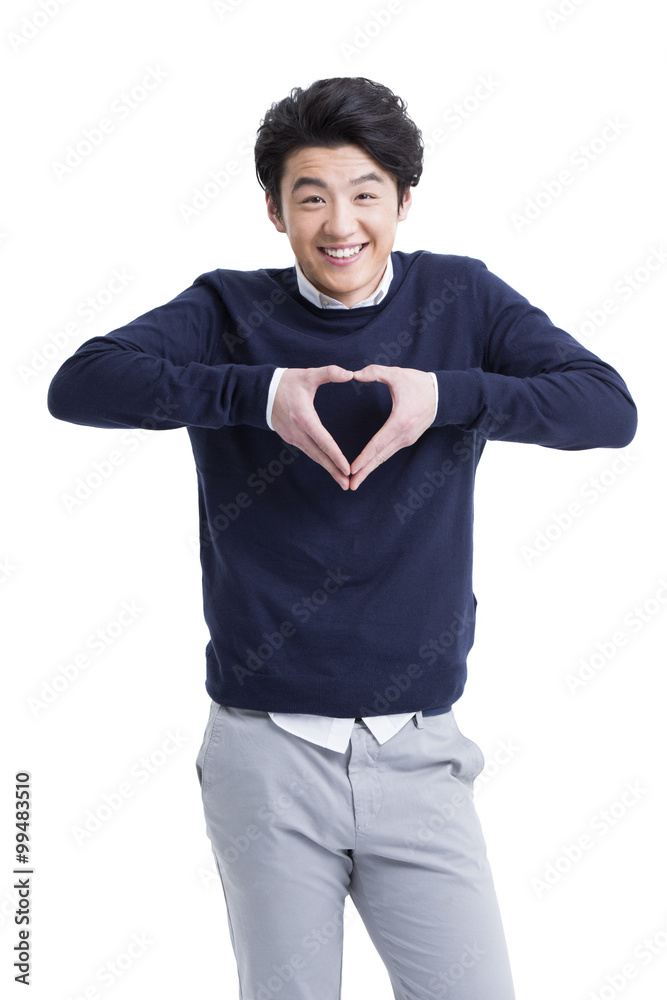 Happy young man doing heart shape gesture