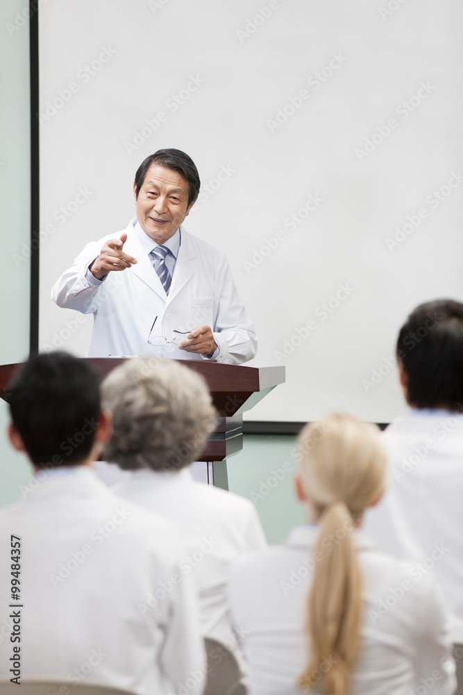 Senior doctor giving speech in boardroom