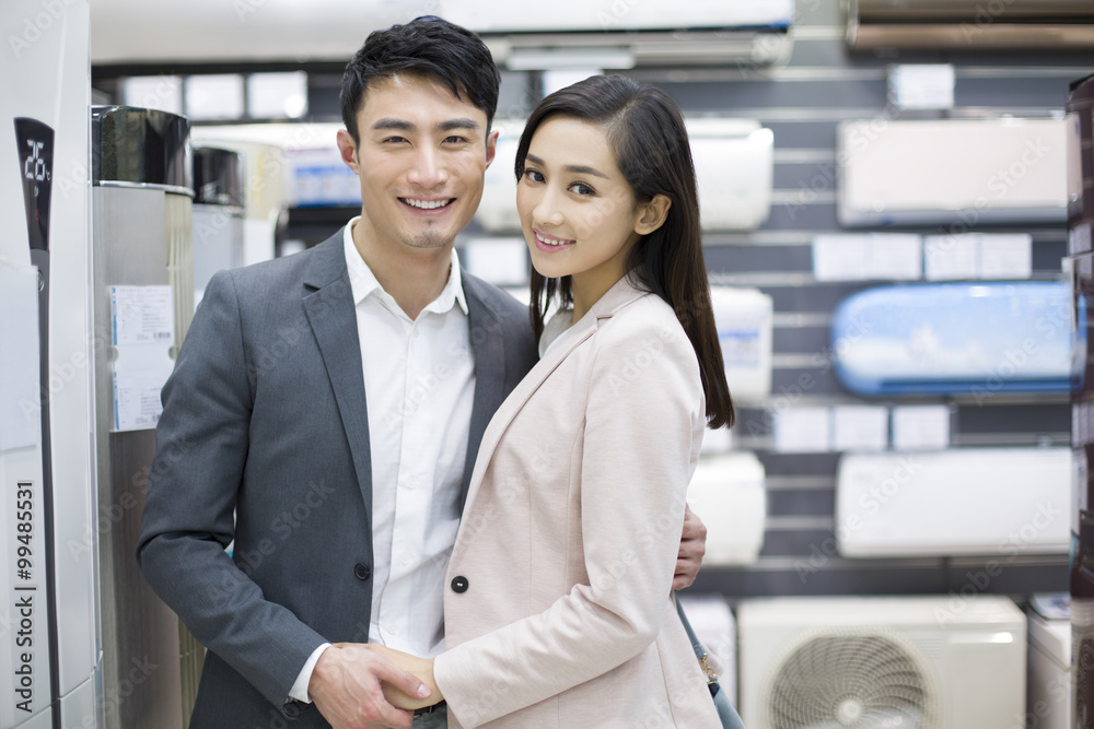 年轻夫妇在电子商店买空调