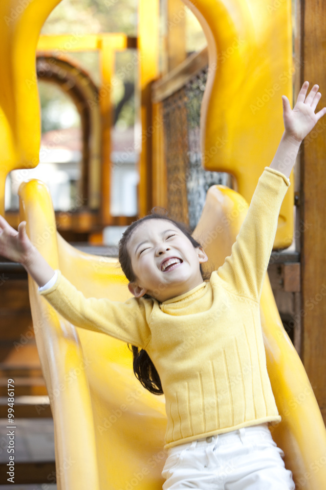 Girl playing on playground slide