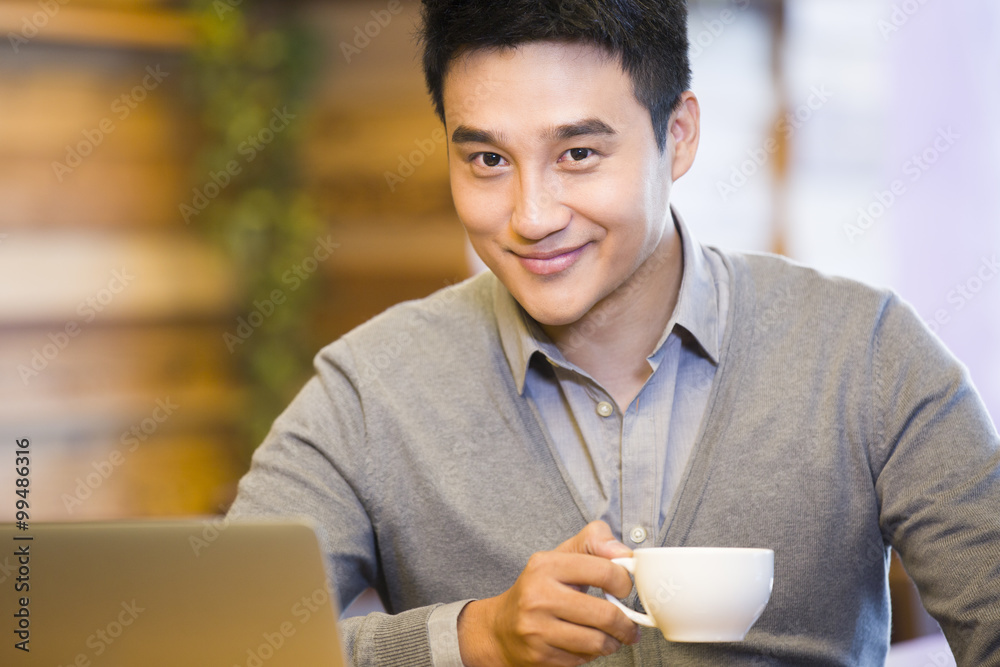 Young man drinking coffee in coffee shop