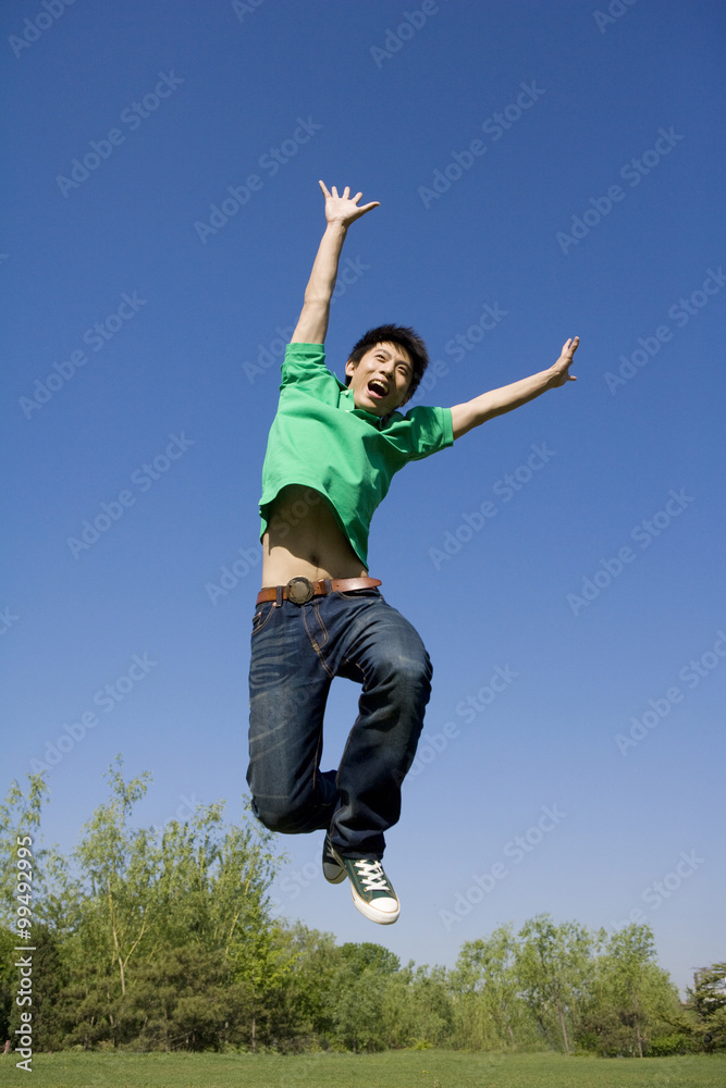 Young man jumping in air at park