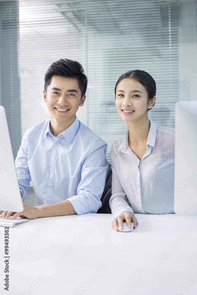 Portrait of young businessman and businesswoman in office