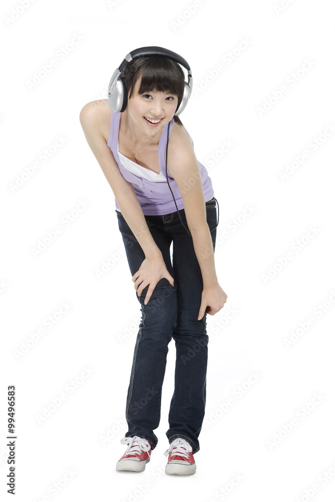 Smiling young woman listening to music on headphones