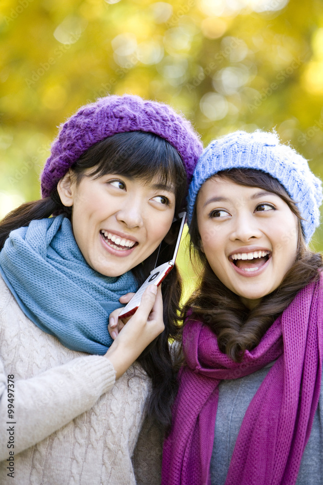 两个年轻女人在听手机