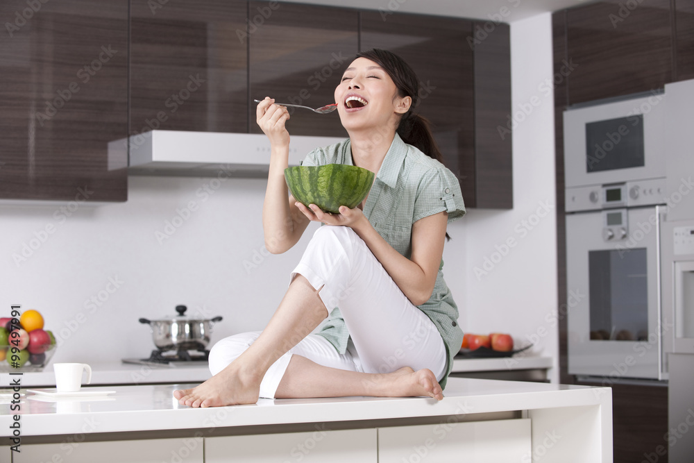 坐在台面上吃西瓜的女人