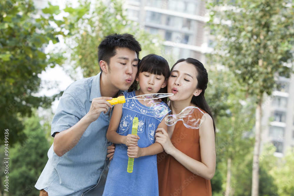 Happy young family blowing bubbles