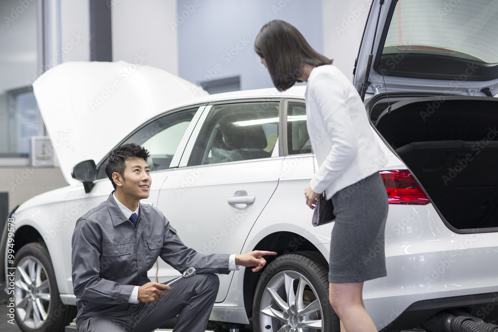 Auto mechanic talking with car owner