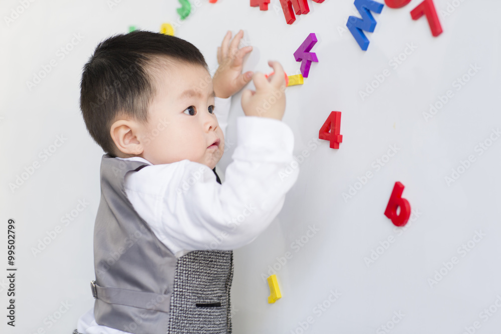 Cute baby playing with alphabet and number toys