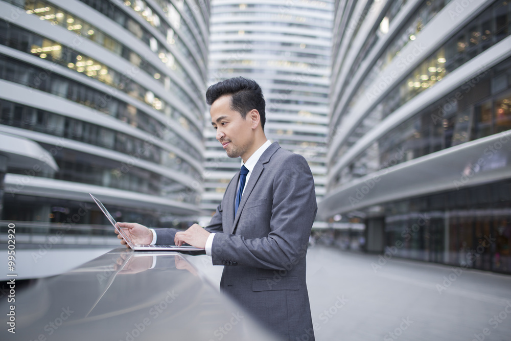 Businessman using laptop outdoors