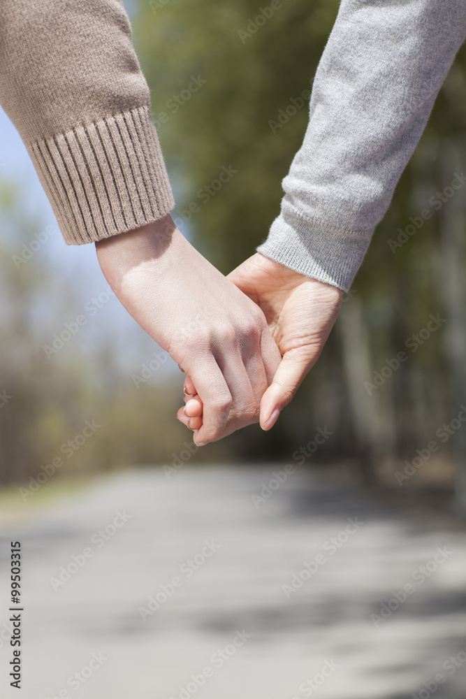 Close up of young couple holding hands