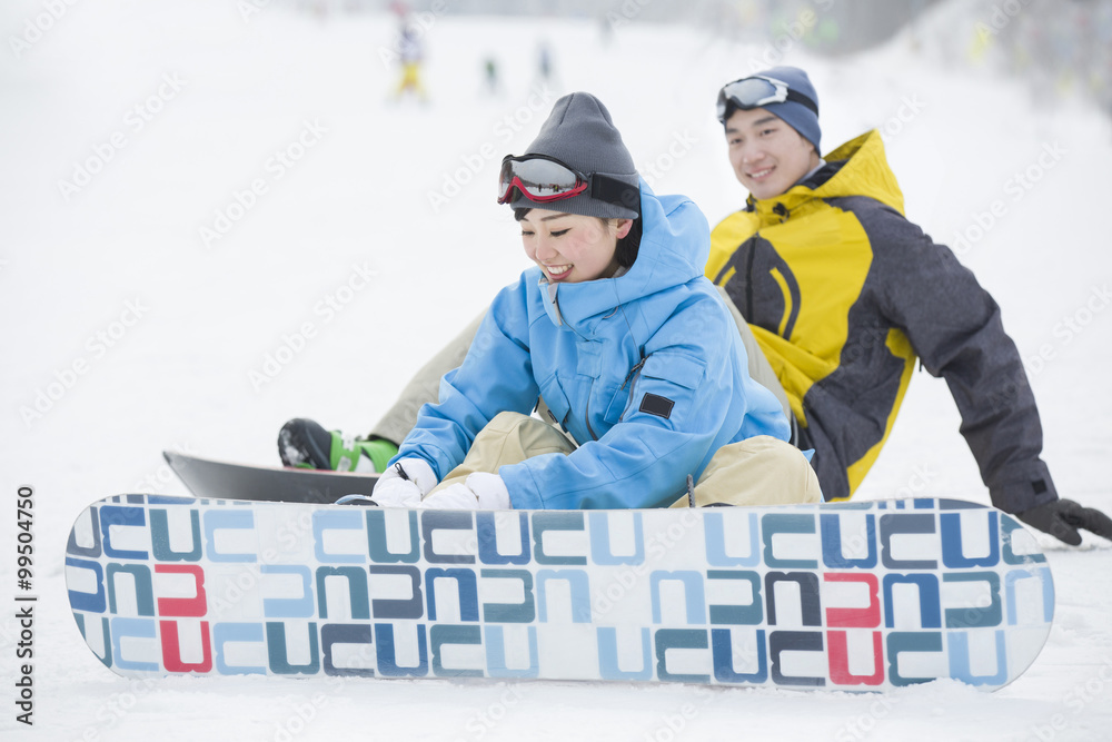 Young couple with snowboards on the snow