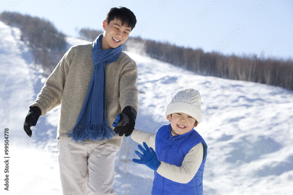 父亲在雪地里和儿子玩耍