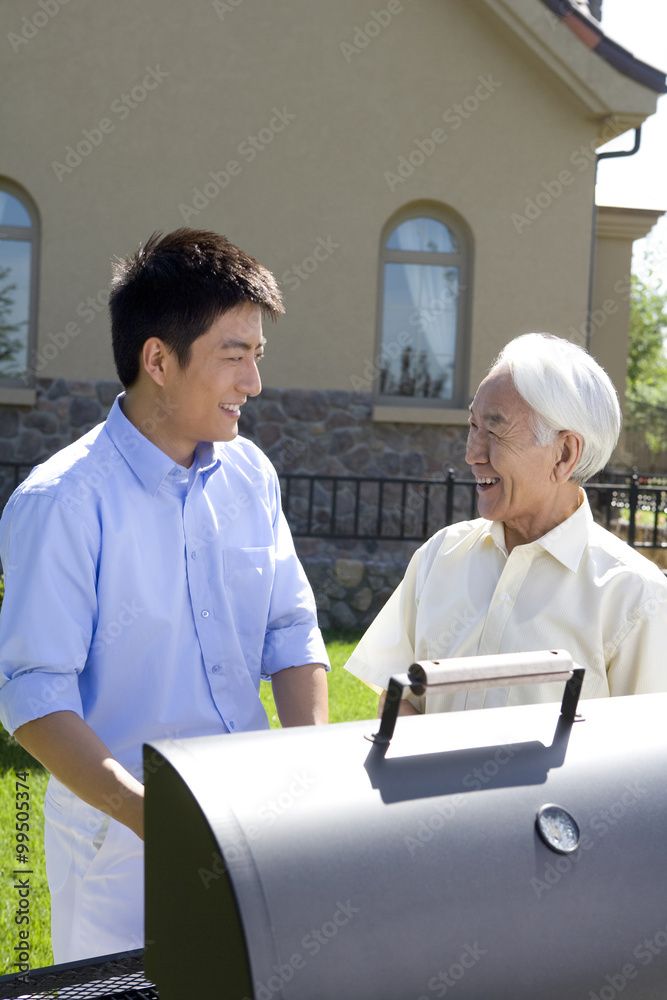 Father and son chatting in front of house