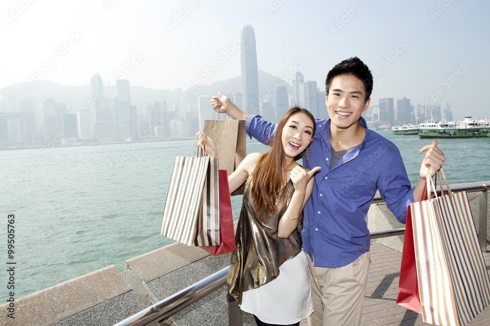 Fashionable young couple with shopping bags enjoying the Victoria Harbor, Hong Kong