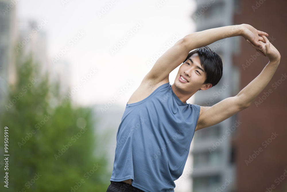 Young man stretching outside