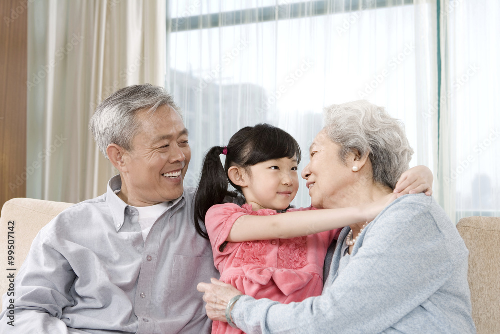 Elderly couple with granddaughter on couch