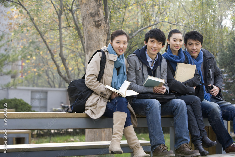 一群大学生坐在公园的长椅上