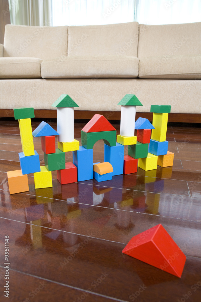 Toy castle made of blocks on hardwood floor